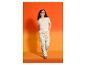 Frau in ESMARA® Wide-Leg-Hose und hellem T-Shirt vor orangefarbenem Hintergrund.