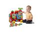 Baby spielt mit roter interaktiver Eisenbahn und Alphabet-Bausteinen.