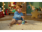 Glückliches Kleinkind spielt mit Holz-Stapelspielzeug auf einem Teppich im Kinderzimmer.