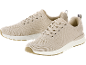 Zwei beige gestrickte Sportschuhe mit weißen Sohlen und braunen Details