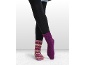 Person trägt schwarze Leggings, eine gestreifte Socke und eine einfarbige lila Socke.