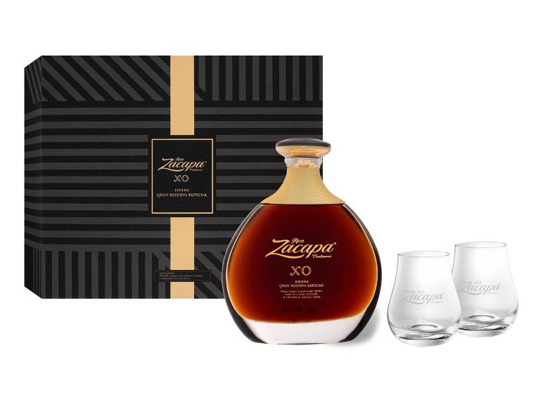 Dunkle Rumflasche mit zwei Gläsern in einer Geschenkbox, mit elegantem Schwarz-Gold-Design.