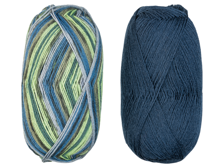 Zwei Garnknäuel, eines mehrfarbig in Blau, Grün und Grau, und eines einfarbig dunkelblau.
