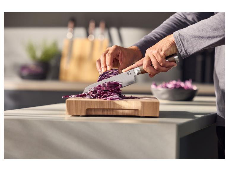 SILVERCREST® Premium Kochmesser schneidet Rotkohl auf einem Schneidebrett.