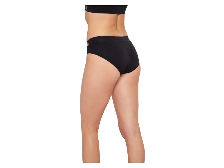 Frau in schwarzem Slip und schwarzem Sport-BH, Seitenansicht.