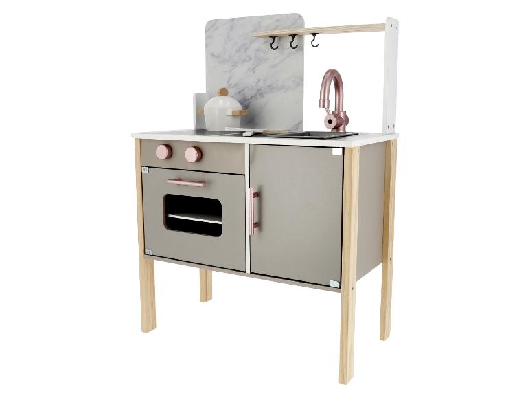 Eine moderne Spielküche mit Marmor-Rückwand, Ofen und Spüle.