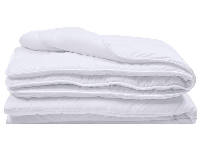 Weiße gefaltete Bettdecke mit genähten Kanten, isoliert auf weißem Hintergrund