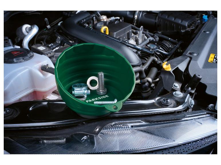 Grüne Magnetschale mit Schrauben und Klemme im Motorraum.