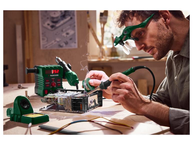 Mann lötet Elektronik mit Parkside-Ausrüstung, einschließlich Lötstation und Lupenbrille.