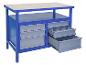 Blaue Werkbank mit Holzplatte und mehreren grauen Schubladen, von denen zwei offen sind.
