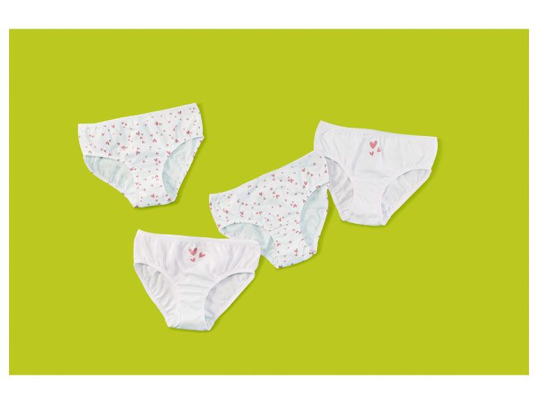 Vier Paar weiße Kinderunterhosen, zwei mit Herzmustern, zwei mit Herzaufdrucken.