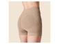 Frau in beigefarbenen, hoch taillierten Shapewear-Shorts mit gerippten Details und Kompressionszonen.