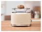 Beiger Toaster mit Brötchen auf dem Brötchenaufsatz, auf einer Holzküchenarbeitsplatte.