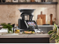 Smarte Küchenmaschine mit Touchscreen in einer modernen Küche mit zubereitetem Essen.