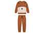 Ein brauner Kinderpullover mit Rentiermotiv und passende Hose.