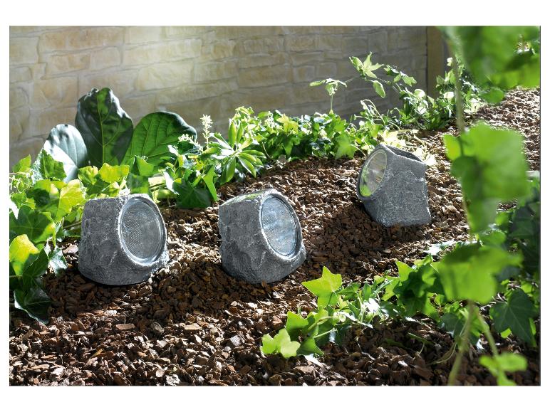 Drei solarbetriebene Gartenleuchten in Steinoptik.