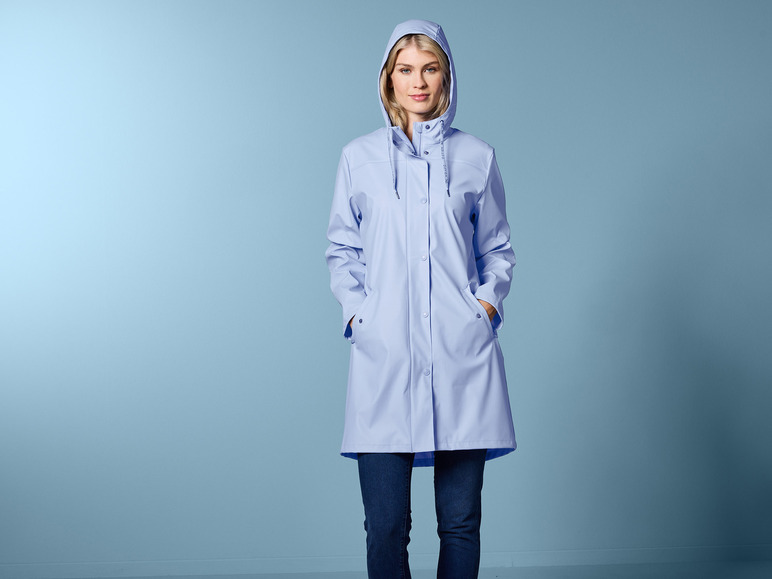 Eine Frau in einem blauen Regenmantel mit Kapuze.
