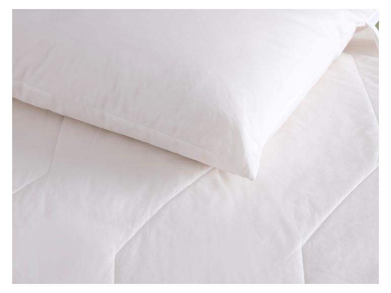 Weißes Kissen und Bettdecke auf einem Bett