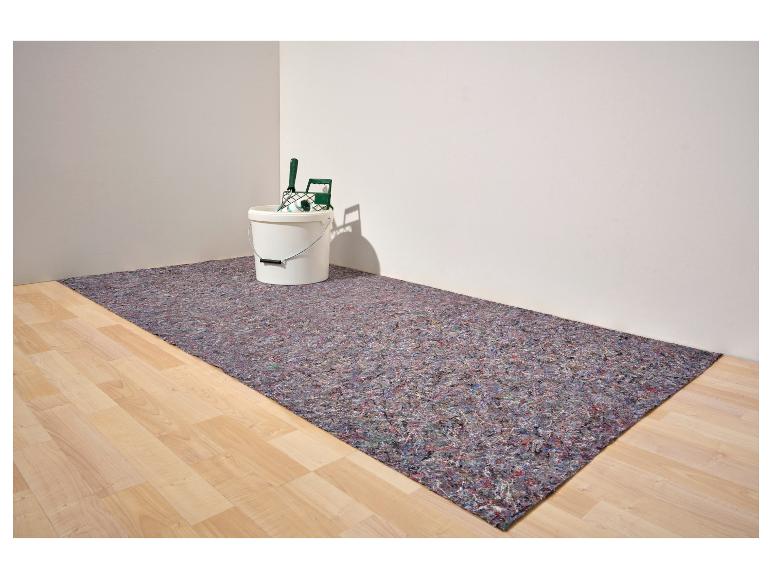 Farbeimer mit Rolle auf Schutzvlies in einem Raum mit Holzboden.