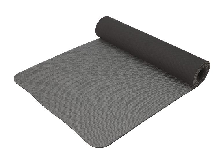 Eine graue Yogamatte, aufgerollt.