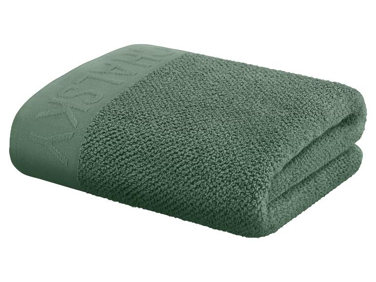 Ein grünes Handtuch auf einem weißen Hintergrund gefaltet.