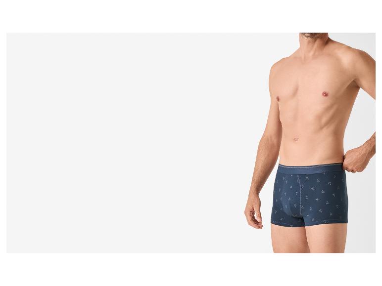 Mann trägt dunkelblaue Boxershorts mit dezentem geometrischem Muster.
