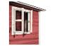 Offenes Holzfenster an einem roten Gartenhaus