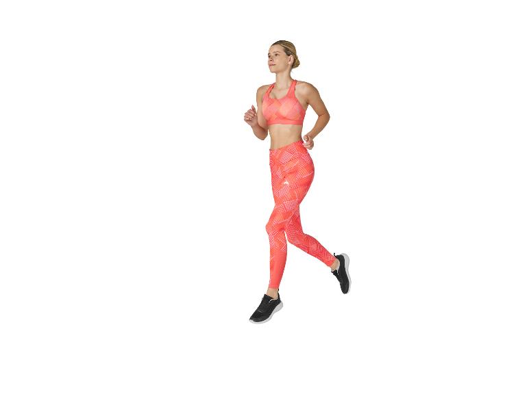 Frau in orangefarbenem Sport-Top und Leggings beim Laufen.