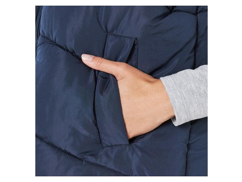 Nahaufnahme einer blauen Winterjacke mit einer Hand in der Tasche.