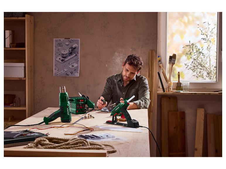 Mann benutzt eine Parkside Lötpistole und Heißluftpistole an einer Werkbank.