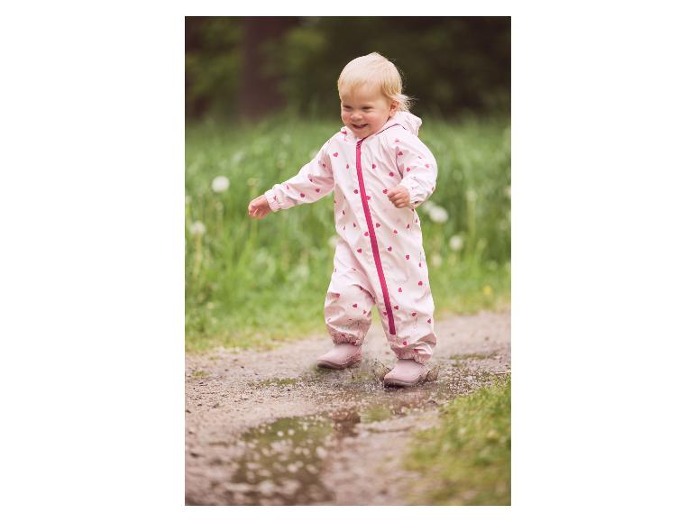 Kleinkind im rosa LUPILU® Matsch- und Buddel-Overall springt in eine Pfütze