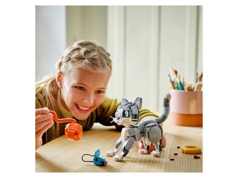 Ein Mädchen spielt mit einer LEGO Katze und Spielzeug.