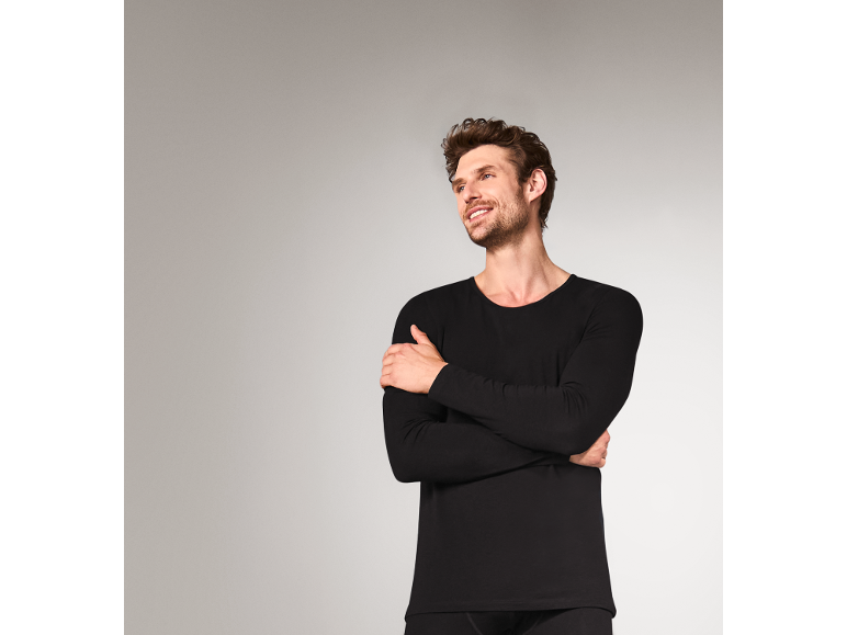 Lächelnder Mann in einem schwarzen Thermo-Langarmshirt.