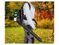 Person mit einem Laubbläser-Rucksack in einem Garten mit Herbstlaub.