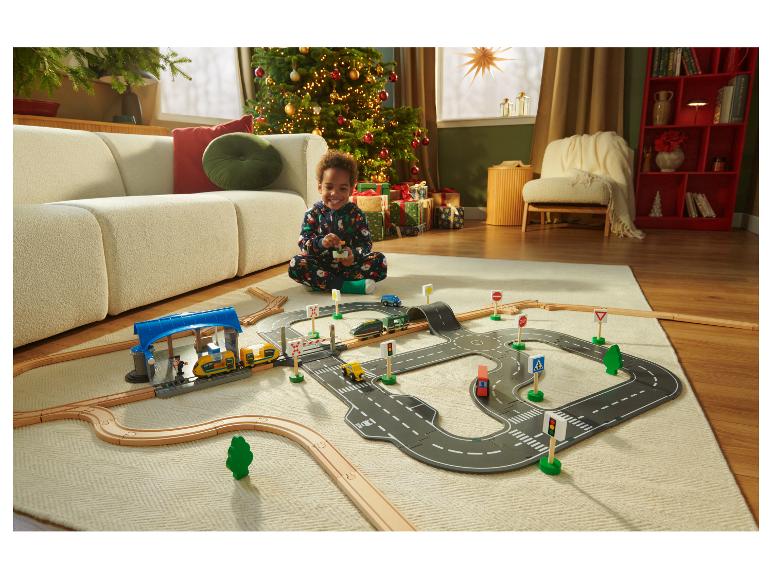 Ein Kind spielt mit der LUPILU® Holzeisenbahn und dem ferngesteuerten Zug.