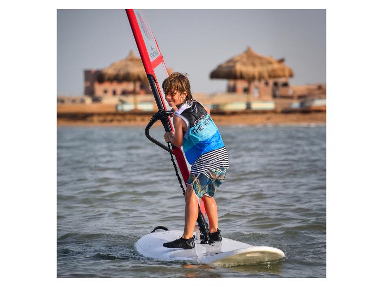 Ein Junge windsurft mit einem Fanatic Windsurfboard.