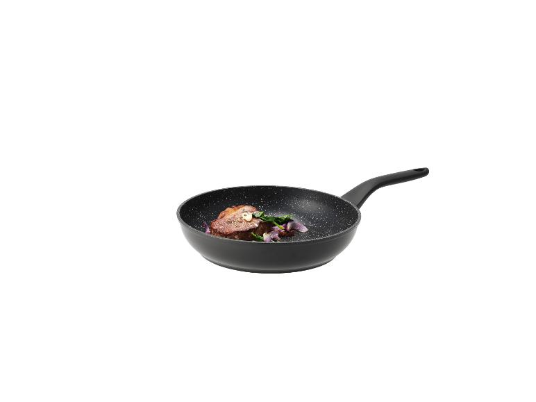 Schwarze Bratpfanne mit Steak, Spinat und roten Zwiebeln