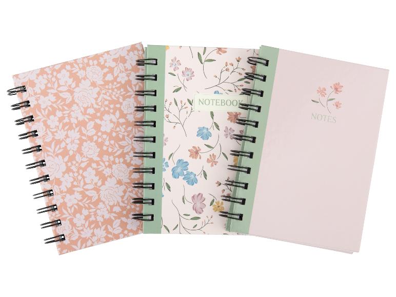 Drei Spiralnotizbücher mit floralen Designs und den Worten „NOTES“ und „NOTEBOOK“.