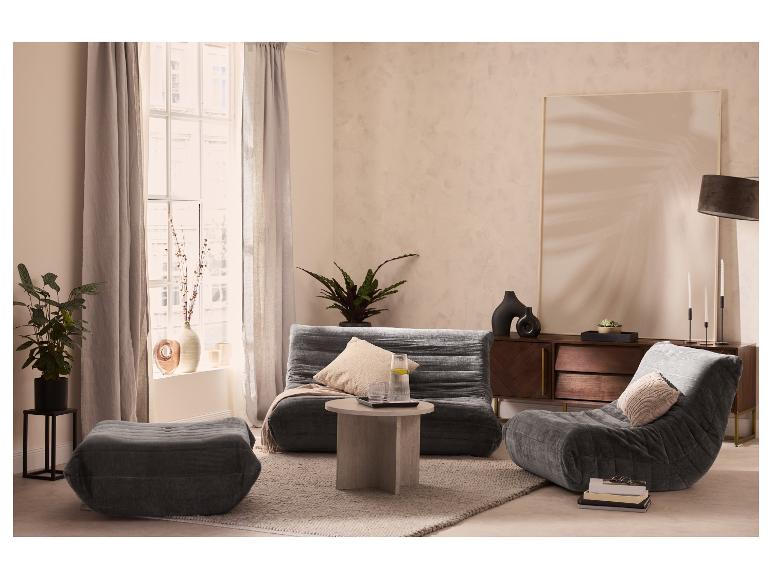 Wohnzimmer mit grauem Modulsofa, passendem Hocker und Loungesessel.