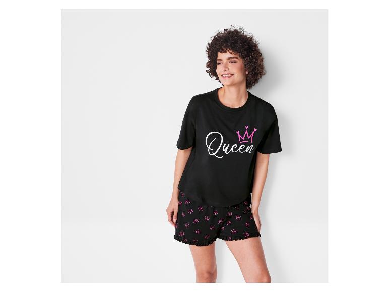 Eine Frau trägt einen schwarzen Pyjama mit einem 'Queen'-Druck und einer Krone.