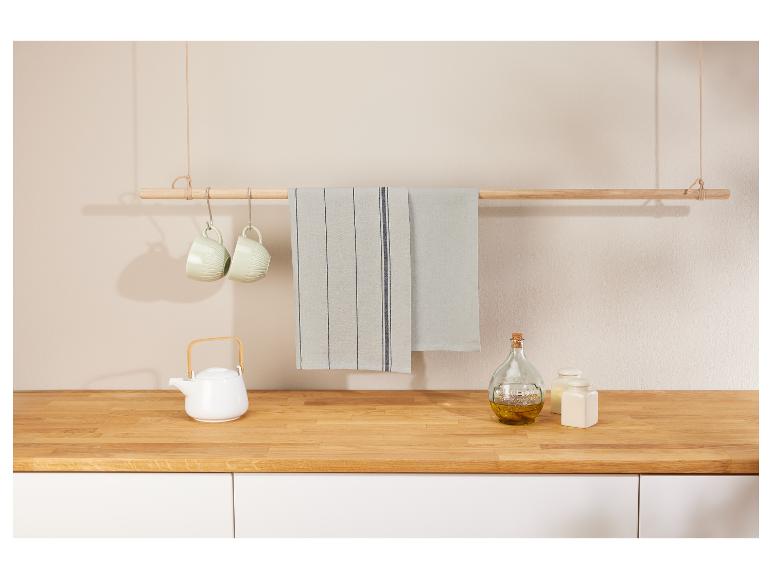 Handtücher, Tassen und Teekanne in einer minimalistischen Küche.