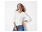 Frau in weißem Langarmshirt und blauen Jeans, lächelnd und nach oben blickend.
