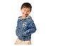 Lächelnder Junge in Jeansjacke mit Cartoon-Hundepatch und beiger Hose.