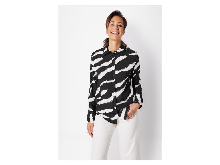 Schwarz-weiß gestreiftes Zebramuster-Shirt und weiße Hose.