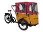Dreirädriges Lastenfahrrad mit Holzkiste und roter Abdeckung