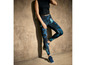 Frau in blauen Leggings mit abstraktem Muster und blauen Sneakern.