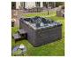 HOME DELUXE Outdoor-Whirlpool Black Marble auf einer Rasenfläche neben der Terrasse.