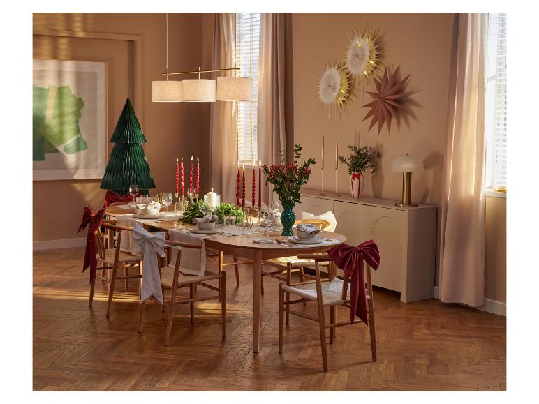 Elegant gedeckter Weihnachtstisch mit Holzstühlen und festlicher Dekoration.