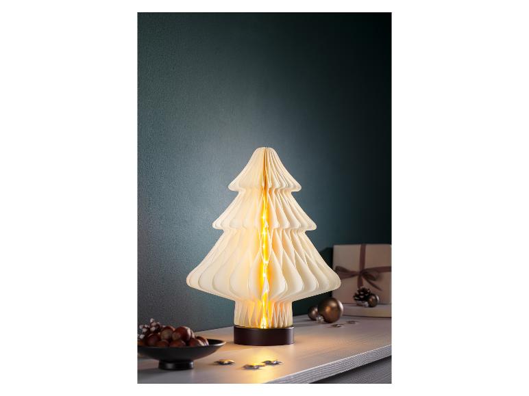 Dekorative Weihnachtsbaumlampe mit warmen Lichtern auf einem Tisch.