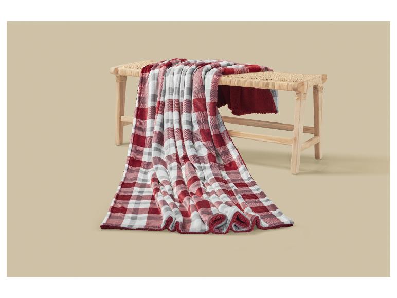 Rot-weiß karierte Decke über einer Holzbank drapiert.